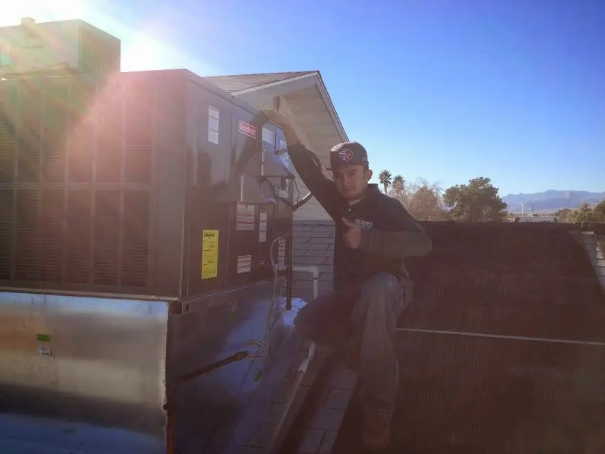 HVAC technician performing Heat Pump Repair on a rooftop unit in Mooresville